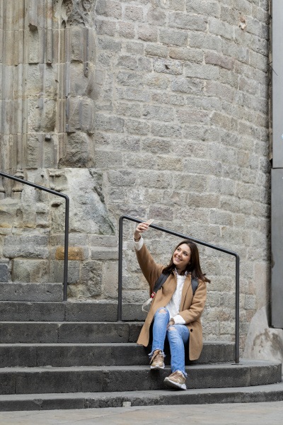 smiling young woman sitting on stairs