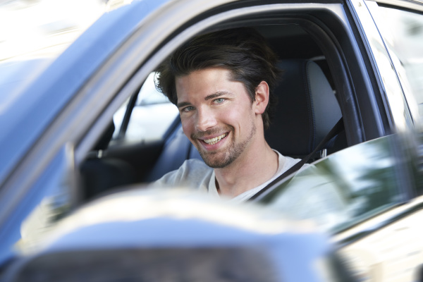 portrait of smiling man driving car
