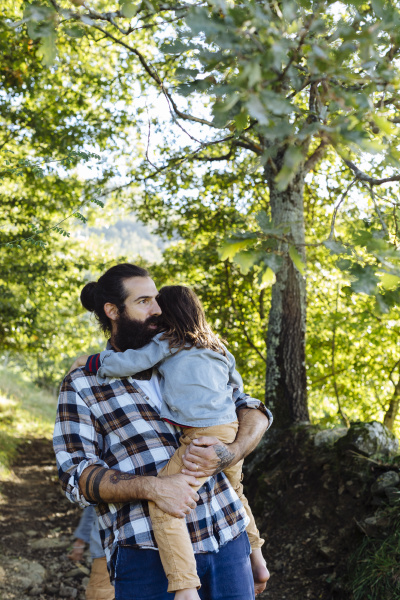 father holding kid in the forest