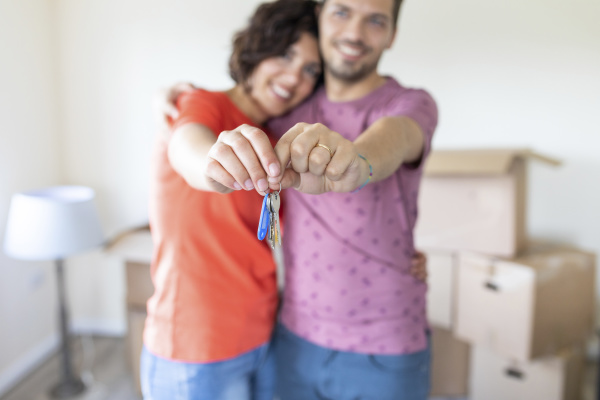 happy couple showing the keys of
