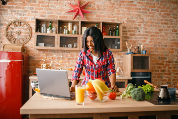 black woman looking recipe on laptop