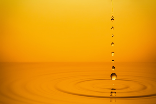 golden oil drops on yellow background
