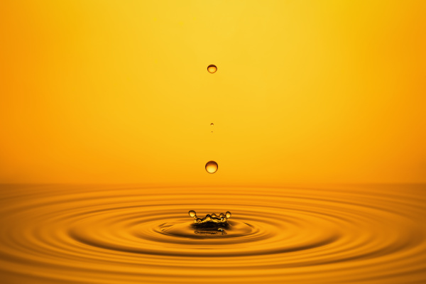 golden oil drops on yellow background