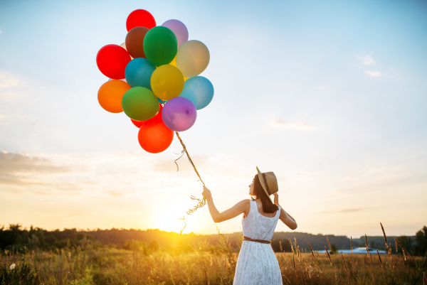 girl with colorful balloons walking in
