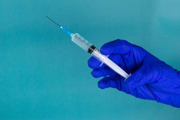 hand with syringe coronavirus vaccine