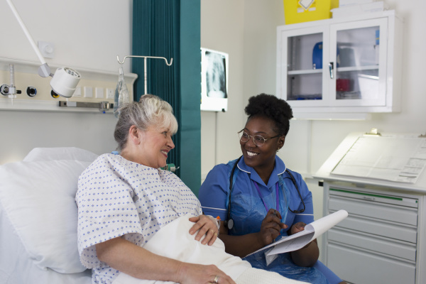 female nurse talking with senior patient