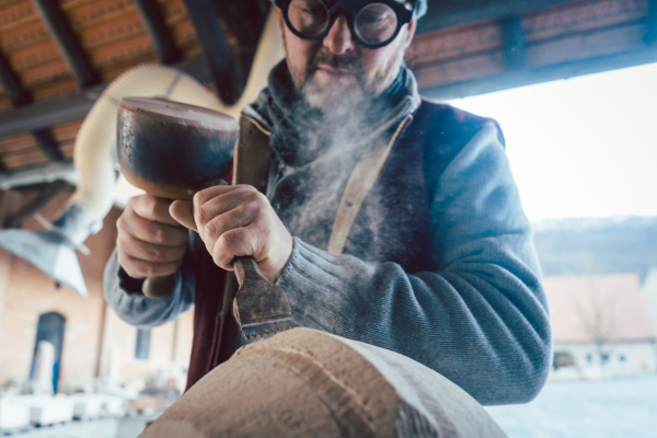 stonemason chiseling stone in his workshop