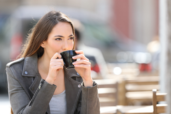 woman drinking coffee looking away on