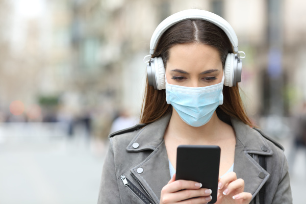 girl with mask and headphones reads