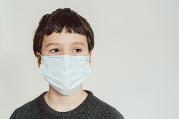 young boy wearing fact mask during