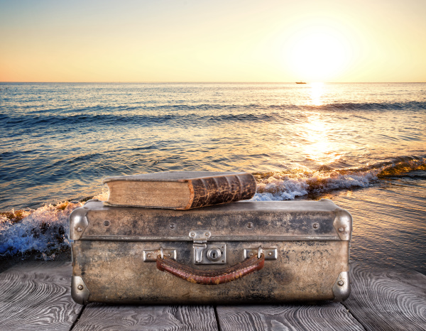 old suitcase with book on wooden