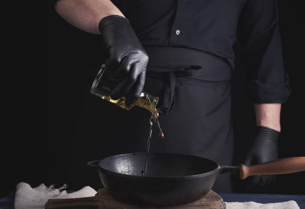 chef in black latex gloves pours