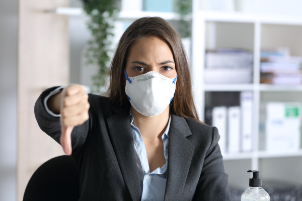 executive wearing mask with thumbs down