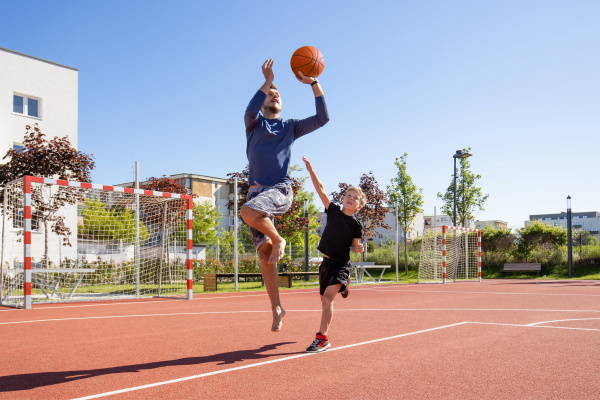 father and son playing basketball barefoot