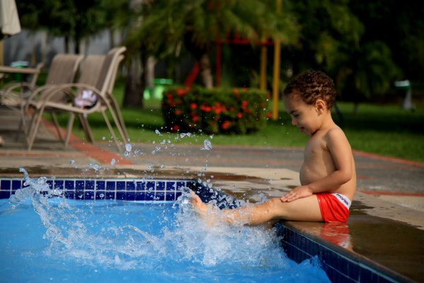 child playing with pool water