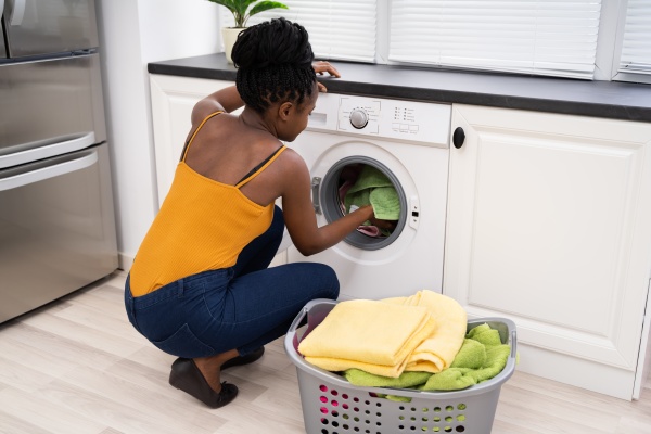 woman loading dirty clothes in washing