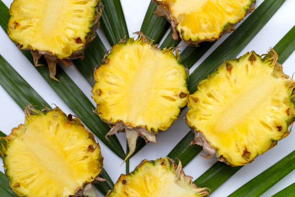 ripe pineapple on tropical palm leaves