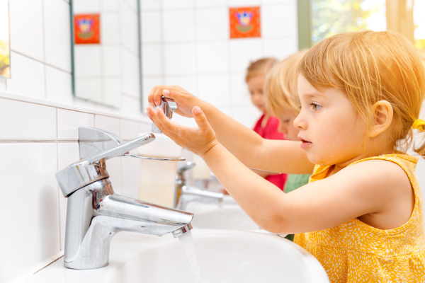 child in kindergarten washing her hands
