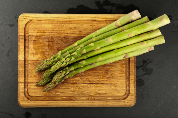 fresh green washed asparagus on wooden
