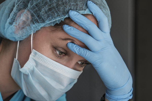 nurse in face mask experiencing symptoms
