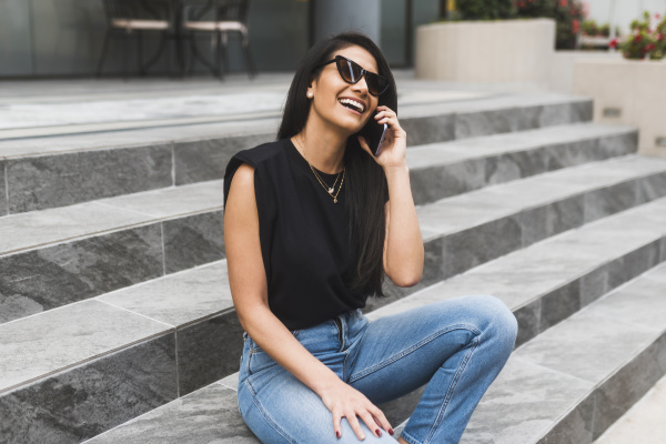 woman with sunglasses using smartphone in