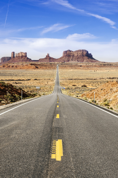 empty desert road towards famous rock