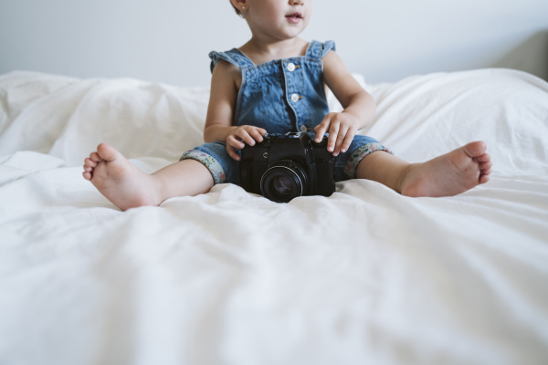 baby girl holding camera at home