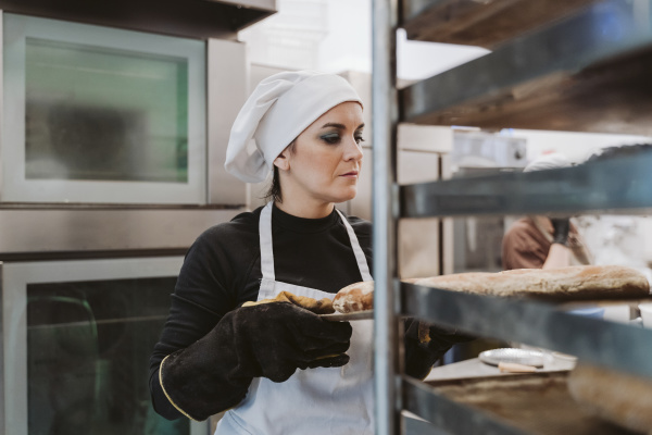 female baker holding baking tray at