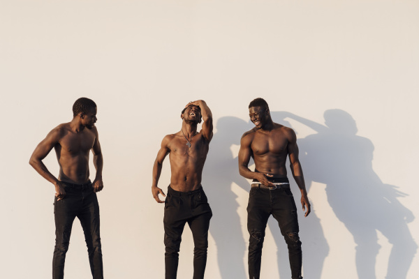 cheerful young male friends standing shirtless