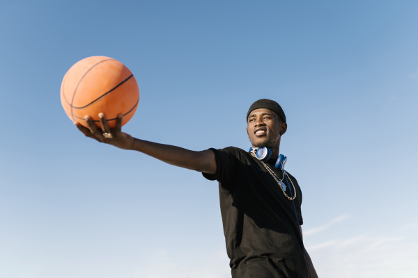 young man holding basketball while standing