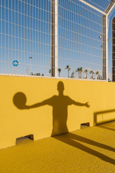 shadow of young man holding basketball