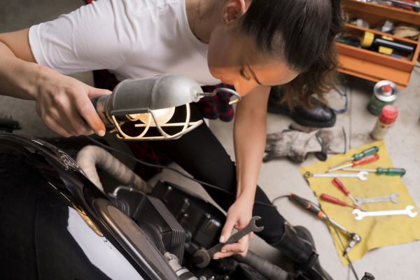 woman repairing motorbike