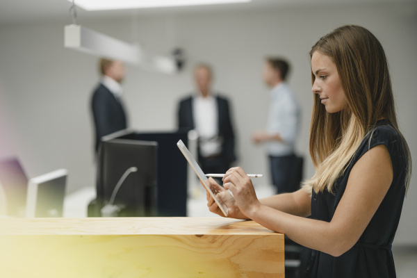 businesswoman standing in office leaning