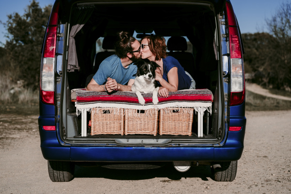 couple with dog kissing in the