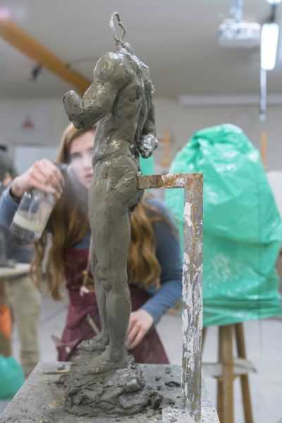 female student spraying water on sculpture