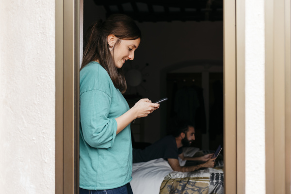 woman using smartphone at open window