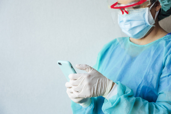 mature female dentist using mobile phone