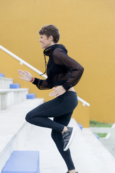 smiling athletic woman running on stairs