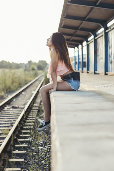 pensive young woman sitting at platform