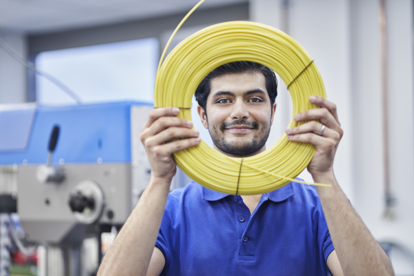 confident male worker looking through rolled