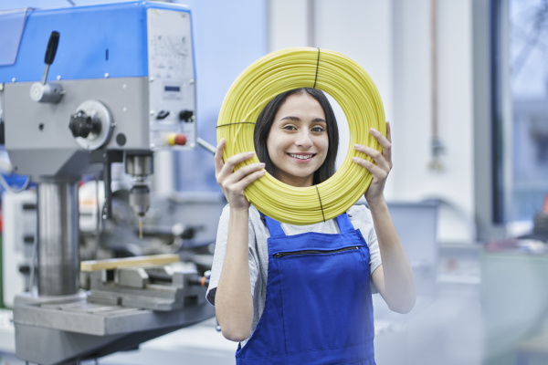 happy female worker looking through rolled
