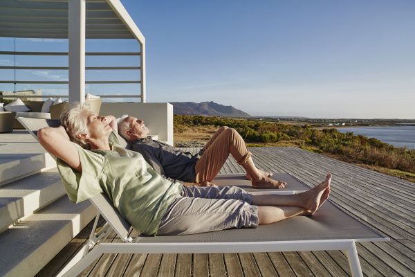 senior couple lying on deck chairs