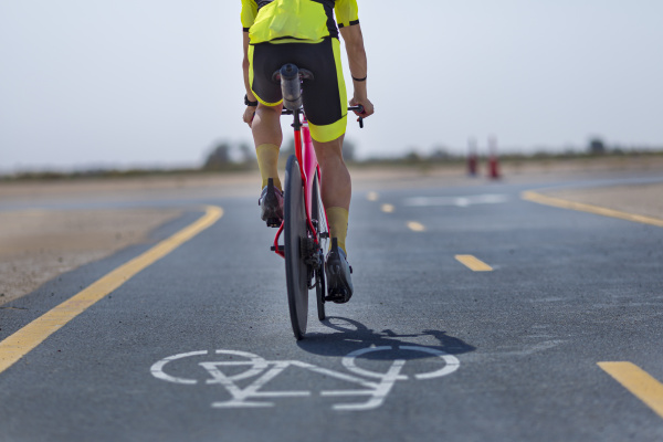 cyclist riding bicycle on road at