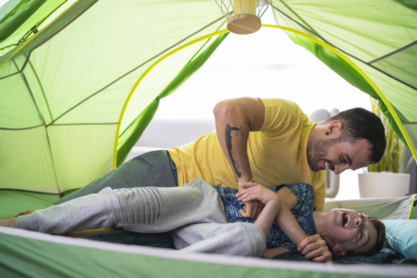father and son playing in tent