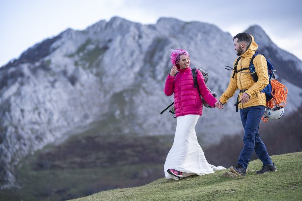bridal couple hiking with backpacks