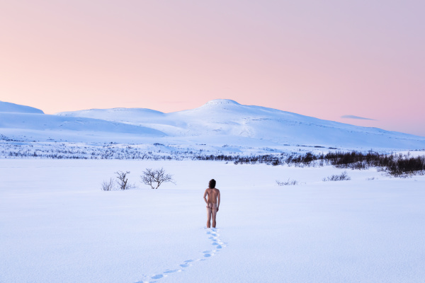 nude man standing in winter landscape
