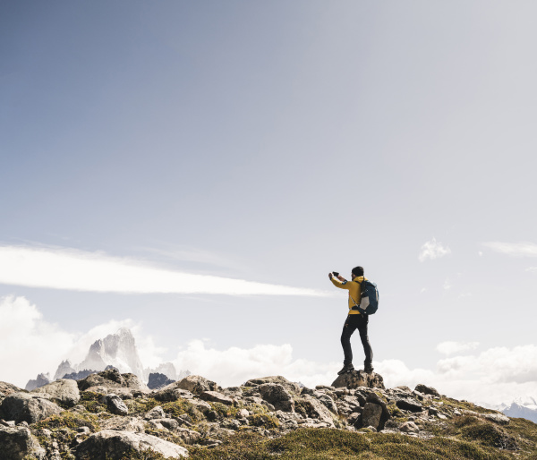 man photographing while standing on mountain