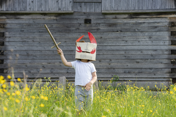 boy wearing mask holding toy sword