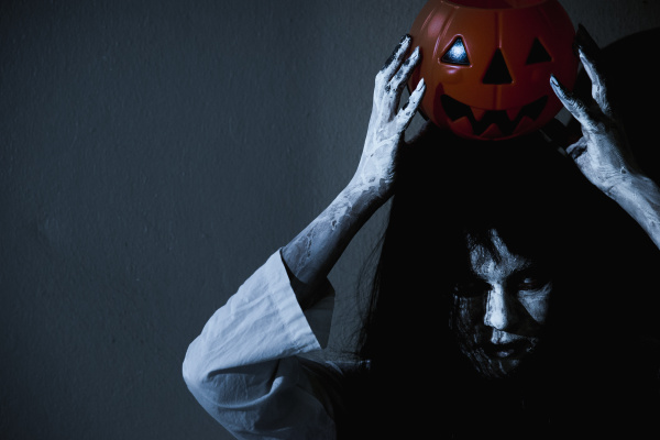 woman ghost horror holding pumpkin above