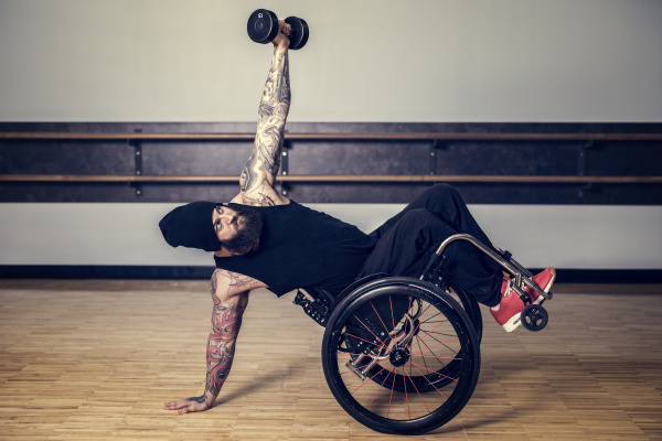 a paraplegic man popping a wheelie